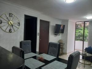 a dining room with a table and a clock on the wall at apartamento 3 habitaciones cerca al parque del poblado in Medellín +6 photos