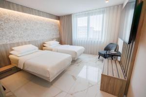 科佩尔Hotel Capris Capodistria Boutique的有两张床和一台电视的酒店房间
