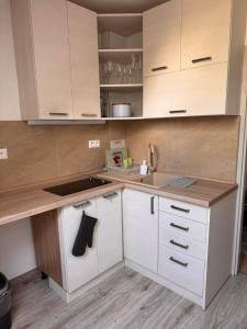 a kitchen with white cabinets and a sink at Apartman RUŽA7 in Ružomberok +2 photos