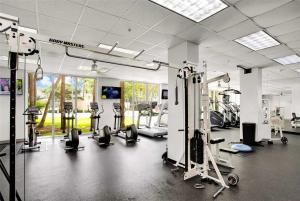 a gym with several treadmills and machines in a room at Beachside Bliss: 1BR Retreat Amenities in Sunny Isles Beach