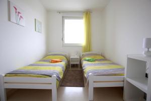 two beds in a small room with a window at Apartment Hurcak in Zagreb