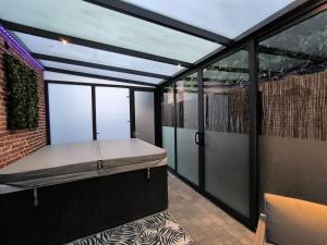 a balcony with a bed and glass walls at Giulia Appart Mairieux in Mairieux