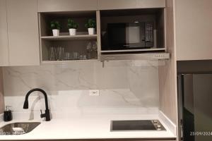 eine Küche mit Mikrowelle und Spüle in der Unterkunft Nuevo Loft cerca a la Embajada Americana, Corferias y Agora in Bogotá + 10 Fotos