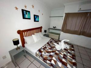 a bedroom with a bed with a checkered blanket at Chi Ibal Hu Cancun in Cancún
