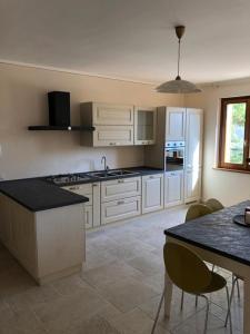 a kitchen with white cabinets and a table and chairs at La Grande Quercia in Montefalco