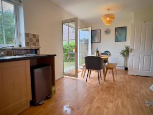 eine Küche und ein Esszimmer mit Tisch und Stühlen in der Unterkunft Waterfoot House in Derry Londonderry