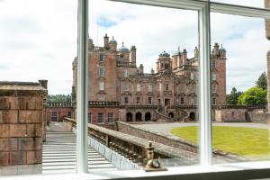 una imagen de un castillo visto a través de una ventana en East Wing, en Thornhill