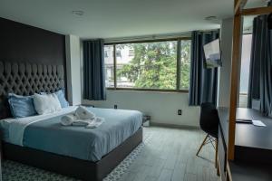 a bedroom with a bed with a teddy bear on it at Casa Romita in Mexico City