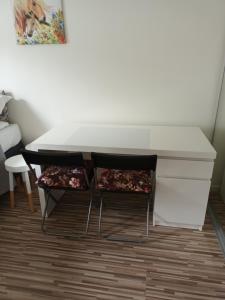 a white desk with two chairs and a table at Holiday room for rent in Tromsø