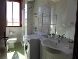 a white bathroom with a sink and a toilet at The Shamrock House in Palazzolo Acreide