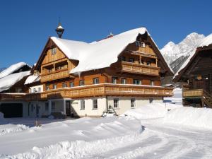 ein großes Gebäude mit Schnee auf dem Dach in der Unterkunft Forsterhof in Ramsau am Dachstein