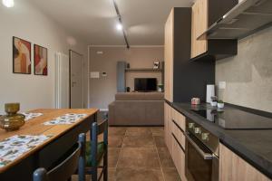 a kitchen with a table and a living room at MiRa Assisi - Rubino in Bastia Umbra +7 photos