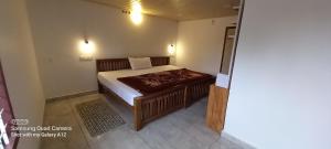 a small bedroom with a bed and a table at Perumaal Homestay in Munnar