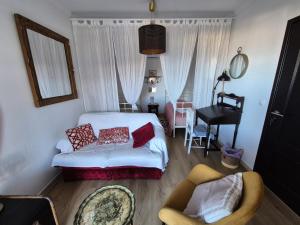 a bedroom with a bed and a chair and a piano at Villa Alegria in Ericeira
