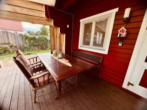 a wooden table and chairs on a deck with a window at VillaHarmony wartet auf Familien mit Hund! in Lommatzsch