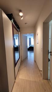 a hallway of an apartment with a mirror and wooden floors at App mit Klima, Pool, Garage für Auto, Bike, Skier, AktivCARD optional in Sankt Englmar