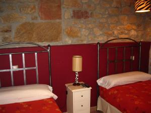 a bedroom with two beds and a lamp on a night stand at Hotel La Pradera de Marta in Quintanaentello