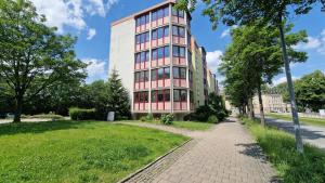 a tall pink building with a sidewalk in front of it at 2 Bedroom Cityview Apartment PS5-QLED TV-Parking in Chemnitz