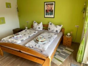two beds in a room with a green wall at Ferienhaus Ahlborn in Uslar