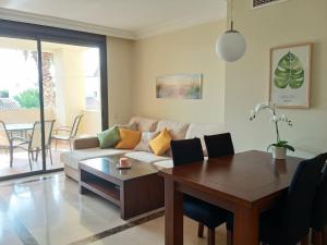 a living room with a couch and a table at Résidence luxe à la mer in Roda