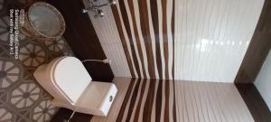 a bathroom with a toilet and a mirror at Perumaal Homestay in Munnar