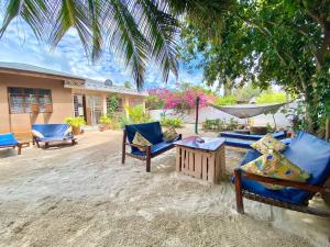 a patio with chairs and a hammock and a house at Samsara Beach House in Kiganga