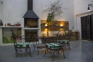 a patio with chairs and a table and a fireplace at Casa Mboyeré in Concepción del Uruguay