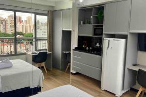 圣保罗Apartamento Studio Vila Mariana的一间厨房,内设一张床和一台冰箱