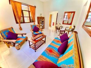 a living room with a couch and chairs at Samsara Beach House in Kiganga