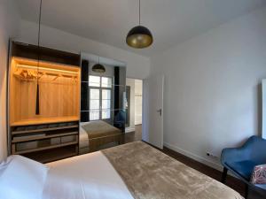 a bedroom with a bed and a blue chair at Lafosse vert avec vue Loire en Centre Ville in Nantes