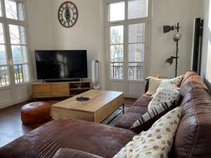a living room with a couch and a tv at Lafosse vert avec vue Loire en Centre Ville in Nantes
