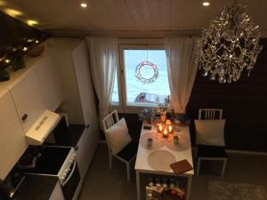 uma cozinha com uma mesa de jantar e um lustre em Nellim Holiday Home em Nellimö