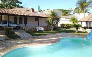 a swimming pool in front of a house at Hospedaria Monterrey - Entre Hortolândia e Monte Mor in Monte Mor