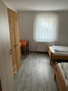 a room with two beds and a table and a window at Ferienwohnung für vier Personen in Helmstadt +4 photos