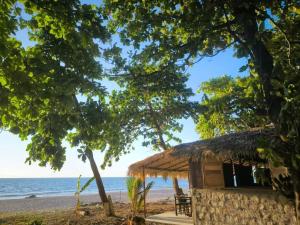 a hut on the beach with the ocean in the background at Bungalow Soa Majunga in Mahajanga