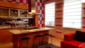 a kitchen with a counter and a red couch at Fuksija House in Daugavpils