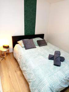 a bed with two pillows and a hat on it at Escale - Maison - Nantes aéroport in Bouguenais