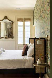 a bedroom with a large bed and a mirror at The Ashley Veranda King Suite with Breakfast in Charleston
