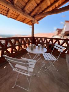 a table and chairs on a balcony with a view of the ocean at Apartamentos GARABATA in Villanueva de la Vera