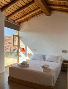 a bedroom with a large white bed with a window at Apartamentos GARABATA in Villanueva de la Vera