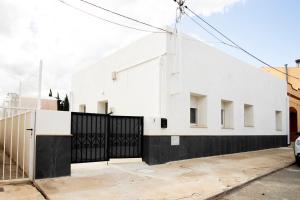 una casa bianca con un cancello nero di La caseta de cinta a El Lligallo del Gànguil