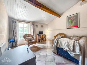 een woonkamer met een bank en een tafel bij Charme rustique avec jardin privé "Au Pastel" in Soupex