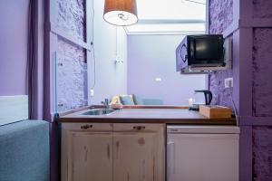 eine kleine Küche mit Spüle und Fernseher in der Unterkunft Apart Hotel Michelle in Odessa