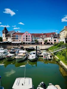 eine Gruppe von Booten, die in einem Hafen mit Gebäuden angedockt sind in der Unterkunft Appartement design et cozy à port cergy in Cergy