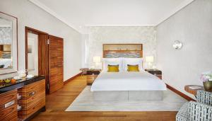 a bedroom with a large bed with yellow pillows at Mandarin Oriental, Munich in Munich