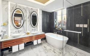 a bathroom with two sinks and a bath tub at Mandarin Oriental, Munich in Munich