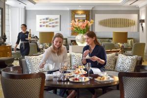 two women sitting at a table eating food at Mandarin Oriental, Munich in Munich