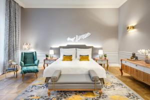 a bedroom with a bed and a green chair at Mandarin Oriental, Munich in Munich
