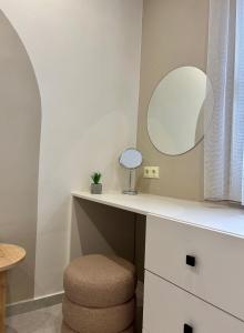 a bathroom with a vanity with a mirror and a stool at Downtown Studio A1Γ in Komotini +2 photos