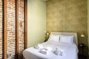 a bedroom with a white bed with towels on it at Innkeepers Quarters Queen Suite with Breakfast in Charleston +16 photos